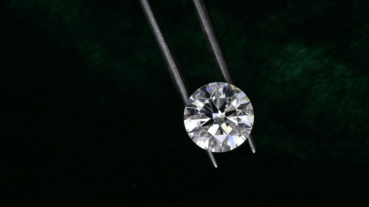 Diamante lapidado solto observado com uma pinça